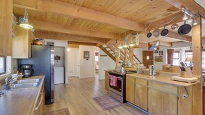 A spacious kitchen with wooden cabinets, a stainless steel refrigerator, and a wooden island with a sink. - Dancing Bear Lodge ~ 1 Mi to Big Bear Lake! (Big Bear Lake)
