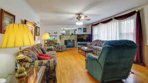 A living room with a sofa, armchair, and a television. - Charming Jefferson City Home: 2 Mi to Downtown! (Jefferson City)