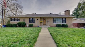 A two-story house with a front yard, a pathway leading to the front door, and a flagpole with an American flag. - Charming Jefferson City Home: 2 Mi to Downtown! (Jefferson City)