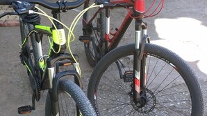 Two bicycles parked on a paved surface with a yellow building in the background. - Seacret Studios - Cozy Jamaican Retreat Apts by RedAwning (Negril)