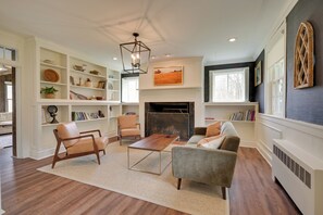 A living room with a fireplace, bookshelves, a sofa, and a coffee table.