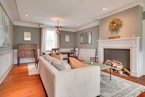 A living room with a sofa, fireplace, and dining area.