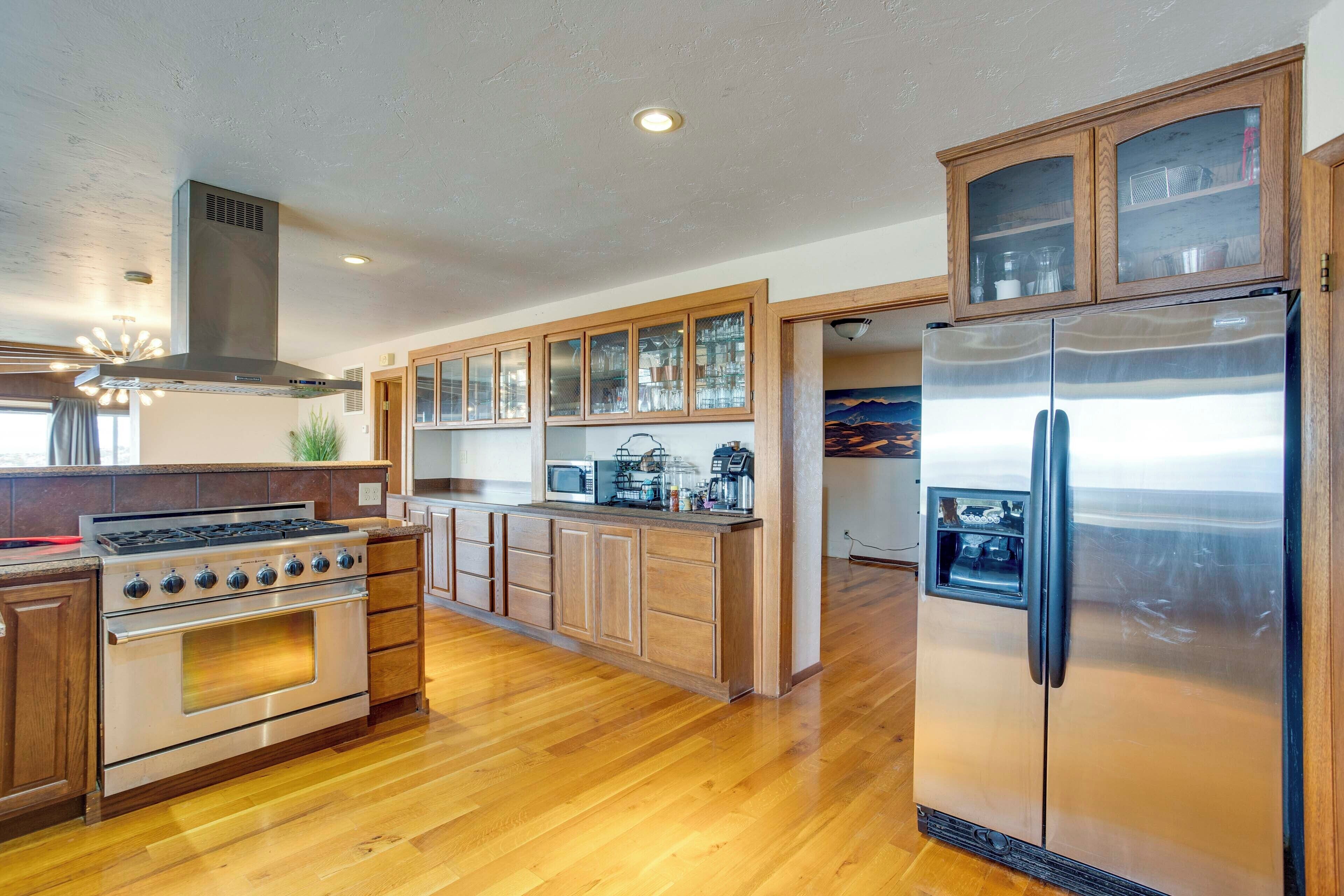 A kitchen with wooden cabinets, a stainless steel refrigerator, a stove, and a microwave.