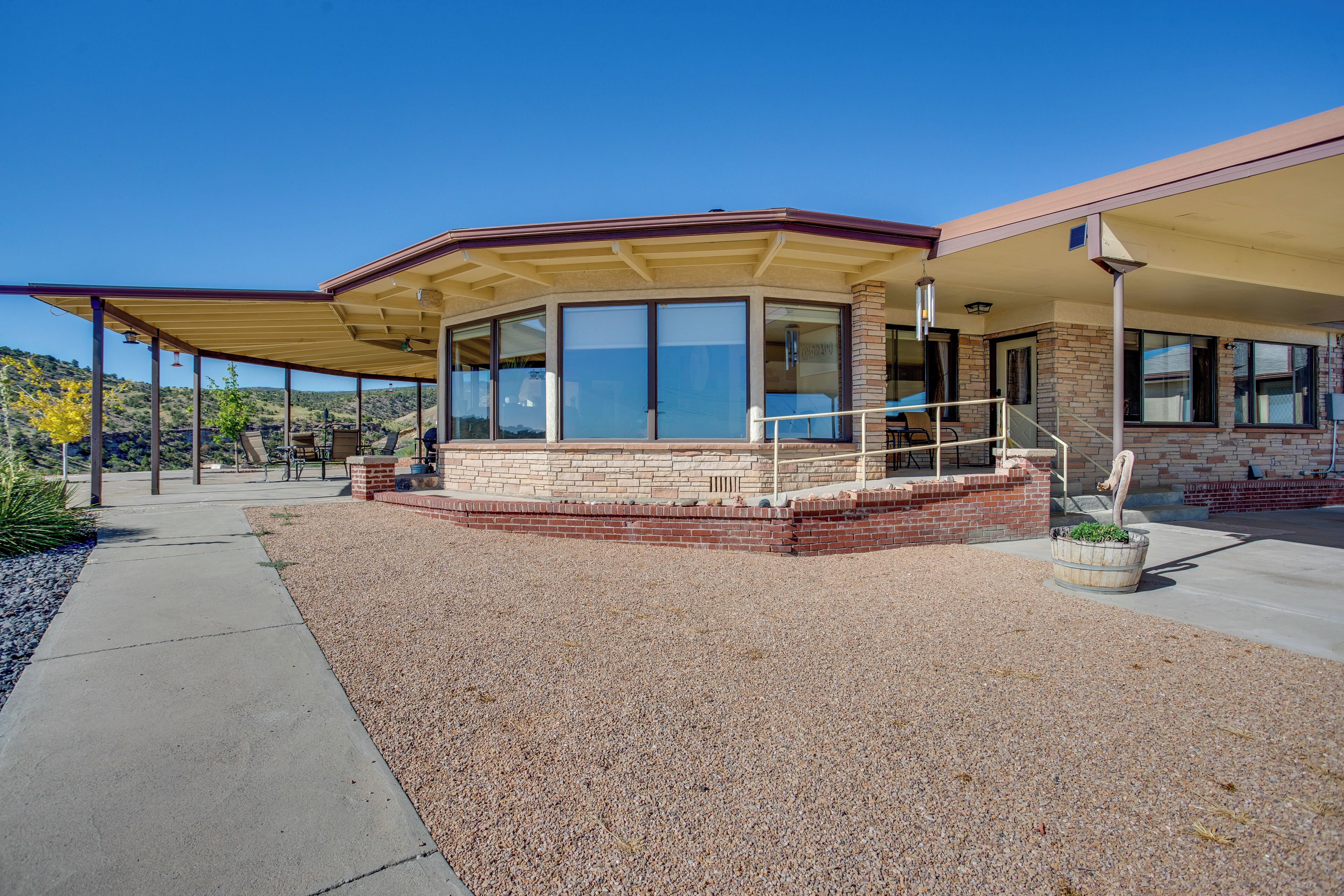 A building with a covered patio area, large windows, and a brick facade.