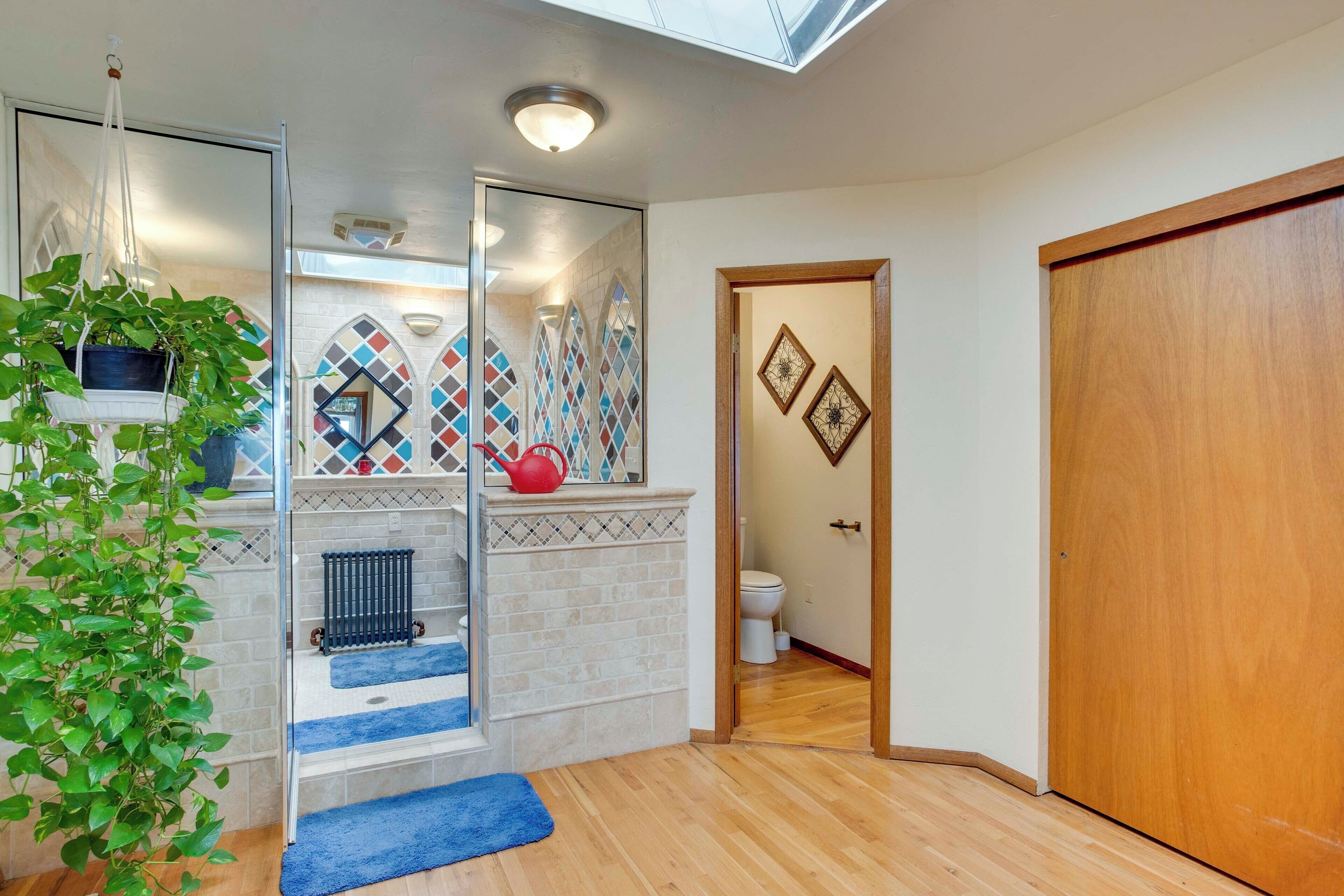 Een moderne badkamer met dakraam, douche, toilet en houten deur.