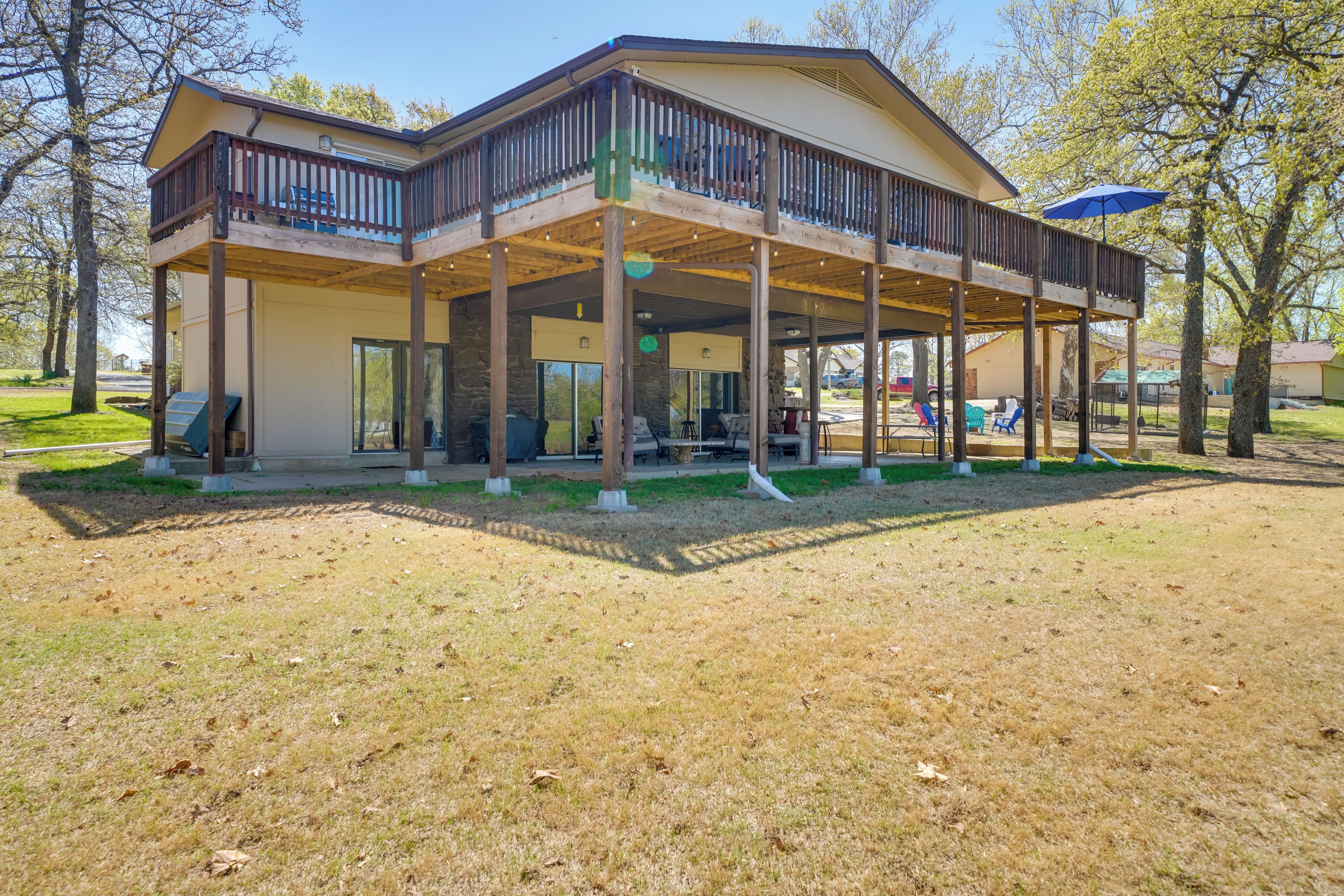 A two-story building with a covered patio area, outdoor seating, and a wooden deck.