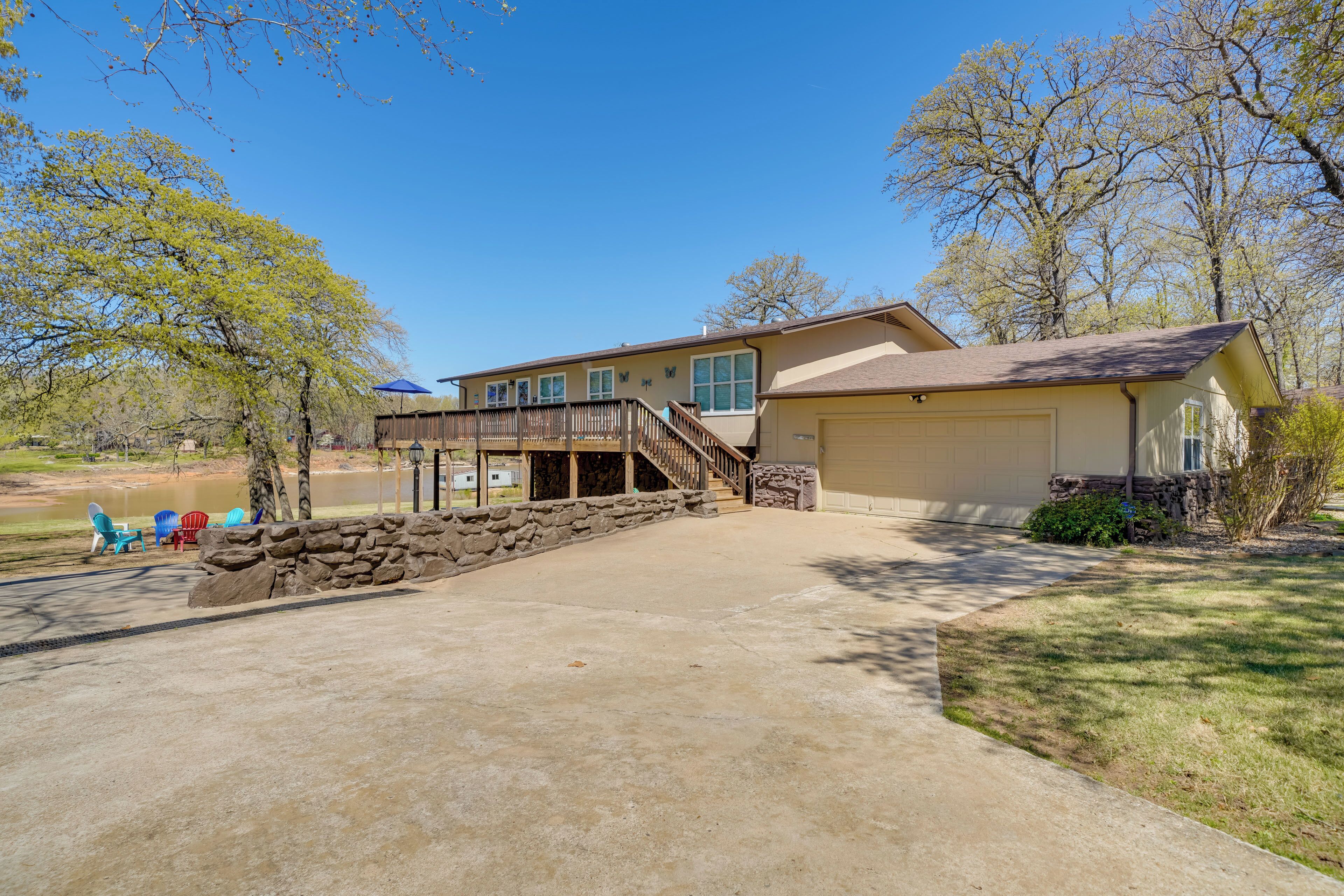 A two-story house with a stone staircase leading to a covered porch, a garage, and a well-maintained lawn.