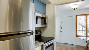 Una cucina con elettrodomestici in acciaio inossidabile, un forno a microonde e un piano cottura.