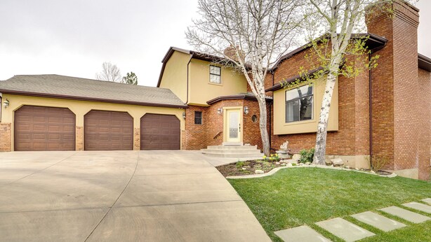 A two-story house with a garage, a front yard with a tree, and a well-maintained lawn. - Orem Vacation Rental Apartment Near BYU Campus! (Orem)