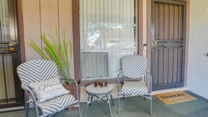 A porch area with two chairs, a small table, and a potted plant. - Peaceful Peoria Vacation Rental: Near Westgate! (Peoria)
