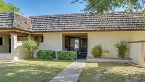 A two-story house with a tiled roof, a front porch, and a small front yard with a pathway leading to the door. - Peaceful Peoria Vacation Rental: Near Westgate! (Peoria)