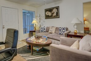 A living room with a sofa, armchair, coffee table, and decorative items.