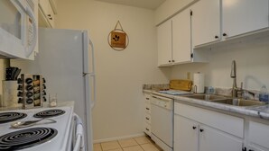 A kitchen with white cabinets, a stove, and a dishwasher. - Peaceful Peoria Vacation Rental: Near Westgate! (Peoria)