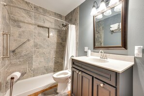 Enjoy a refreshing shower or soak in the bathtub in this bathroom.
