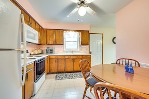 Enjoy meals in this kitchen with microwave, stove, and sink, and dine at the adjacent table with two chairs.