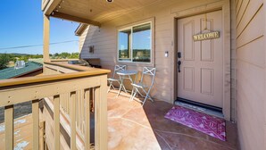 A wooden deck with a table and chairs, a welcome sign, and a door with a doormat. - 2 Mi to Lake: Apt w/ Balcony in Payson! (Payson)