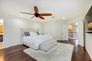 A bedroom with a large bed, a ceiling fan, and a white fluffy rug. - Spacious Surprise Vacation Rental Near Phoenix! (Surprise)