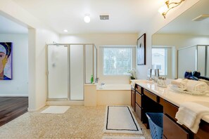 A modern bathroom with a glass shower enclosure, a bathtub, and a vanity with a large mirror. - Spacious Surprise Vacation Rental Near Phoenix! (Surprise)