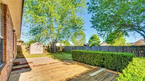 A wooden deck with a brick wall, a hedge, and a wooden fence in the background. - 2 Mi to Uca: Group Getaway w/ Private Yard! (Conway)