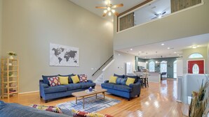 A spacious living room with two blue sofas, a wooden coffee table, and a world map on the wall. - Houston Townhome By George Brown Convention Center (Houston)