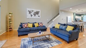 A modern living room with two sofas, a coffee table, and a world map on the wall. - Houston Townhome By George Brown Convention Center (Houston)