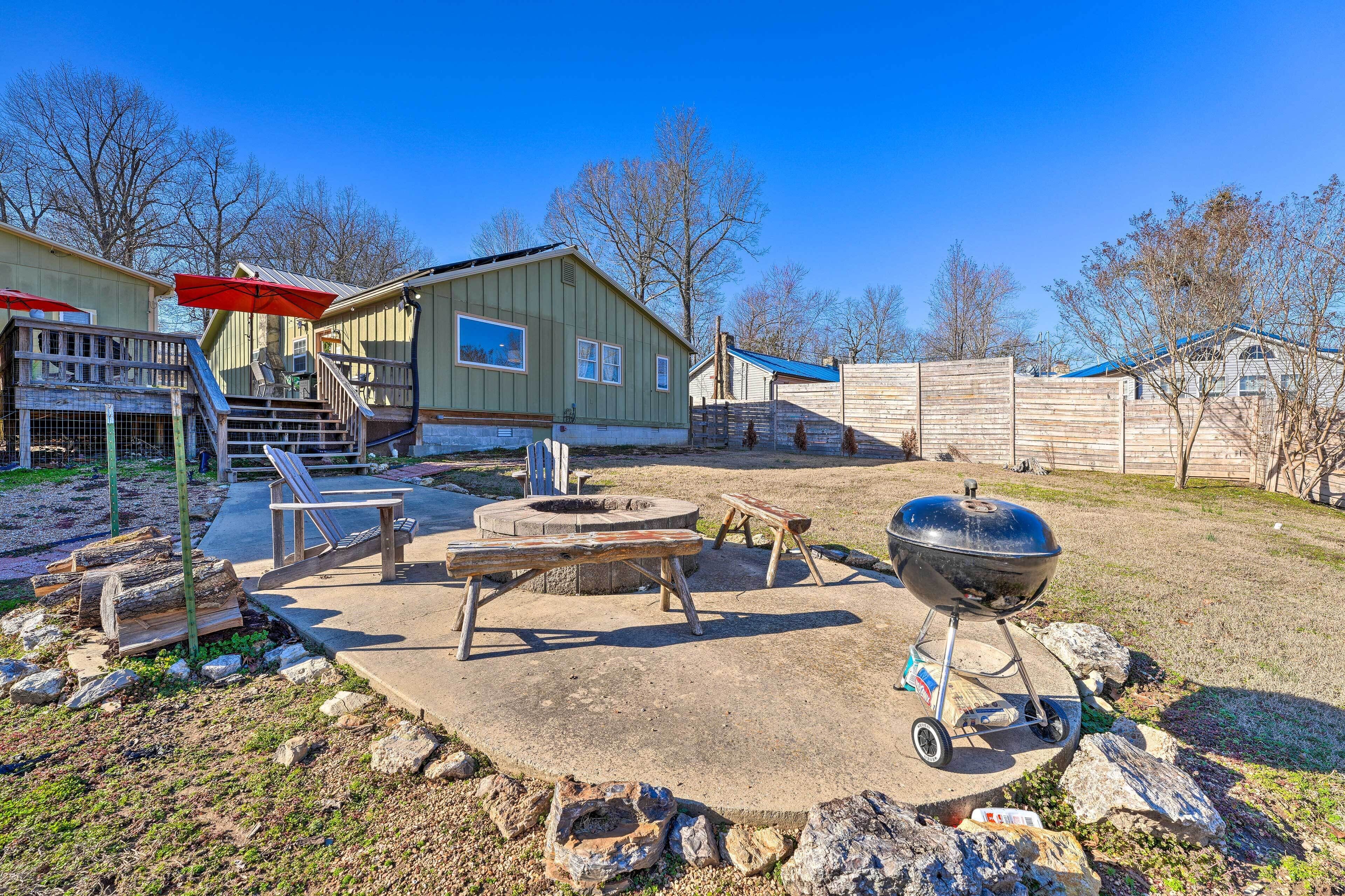 Un jardin avec un barbecue, un espace salon extérieur et une terrasse en bois.