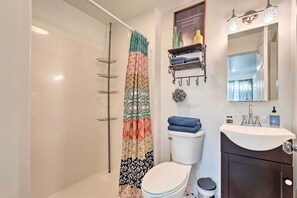 A bathroom with a shower, toilet, sink, and a mirror. - Boho Mountain Home Escape, Walk to Marina! (Mountain Home)