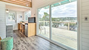 A modern kitchen with a large sliding glass door leading to an outdoor deck. - Updated Texas Tiny Home Rental on Lake Travis (Spicewood)
