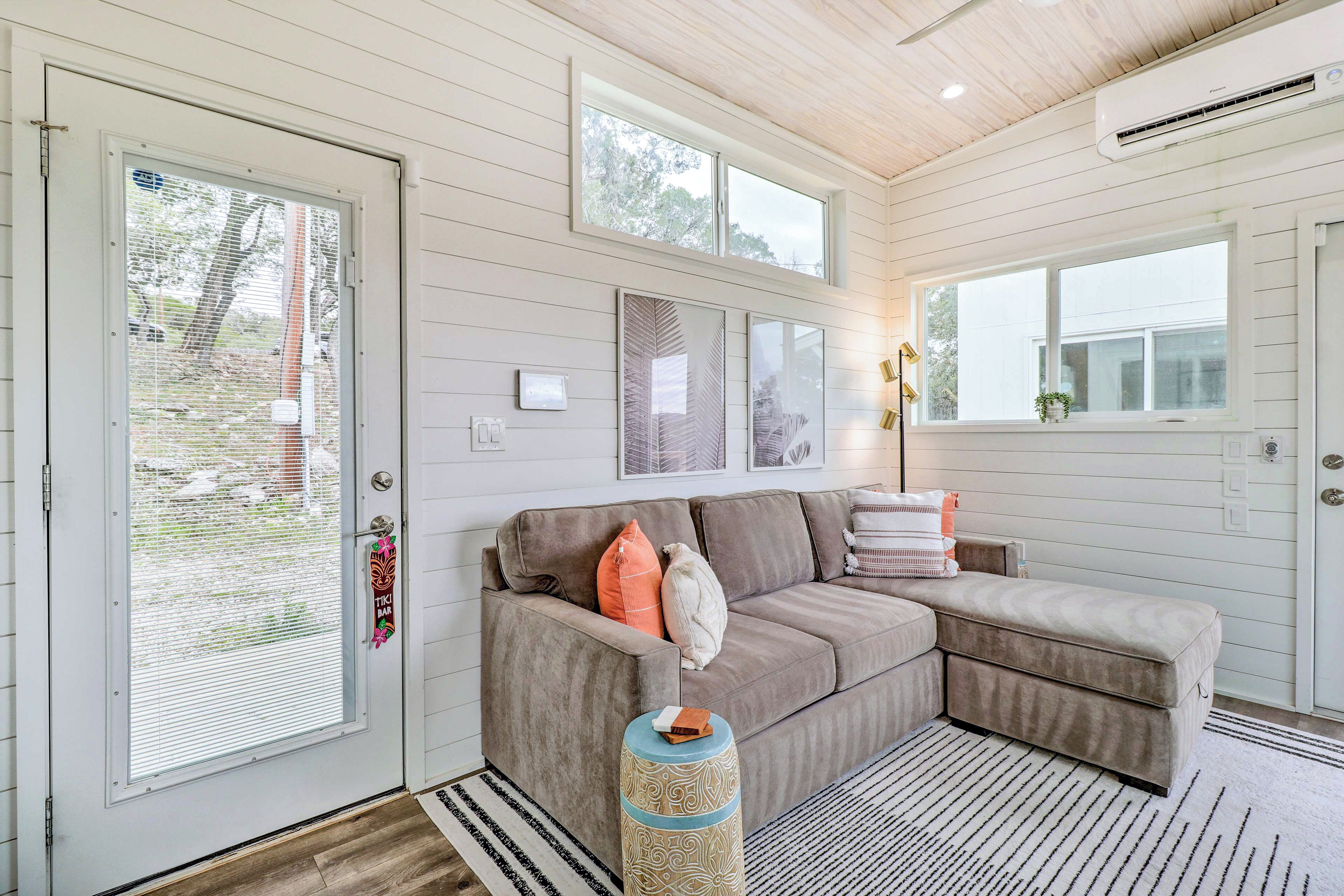 A cozy living room with a sectional sofa, a round side table, and a large window providing natural light.