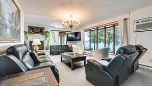 A living room with a fireplace, leather sofas, a coffee table, and a TV. - Riverfront Sault Ste Marie Home w/ Dock! (Sault Ste. Marie)