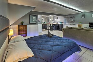 A bedroom with a large bed, a sofa, a desk, and a kitchenette. - Portage Studio: 11 Miles to Indiana Dunes! (Portage)