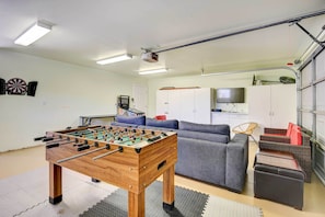 A room with a foosball table, grey sofa, and a television. - Frazier Park Vacation Rental w/ Game Room & Views! (Frazier Park)