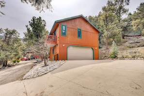 A two-story wooden house with a balcony, garage, and a driveway leading to the front door. - Frazier Park Vacation Rental w/ Game Room & Views! (Frazier Park)