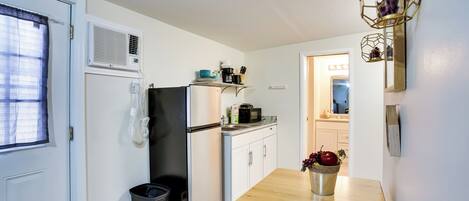 A compact kitchen with a refrigerator, microwave, and a small countertop.
