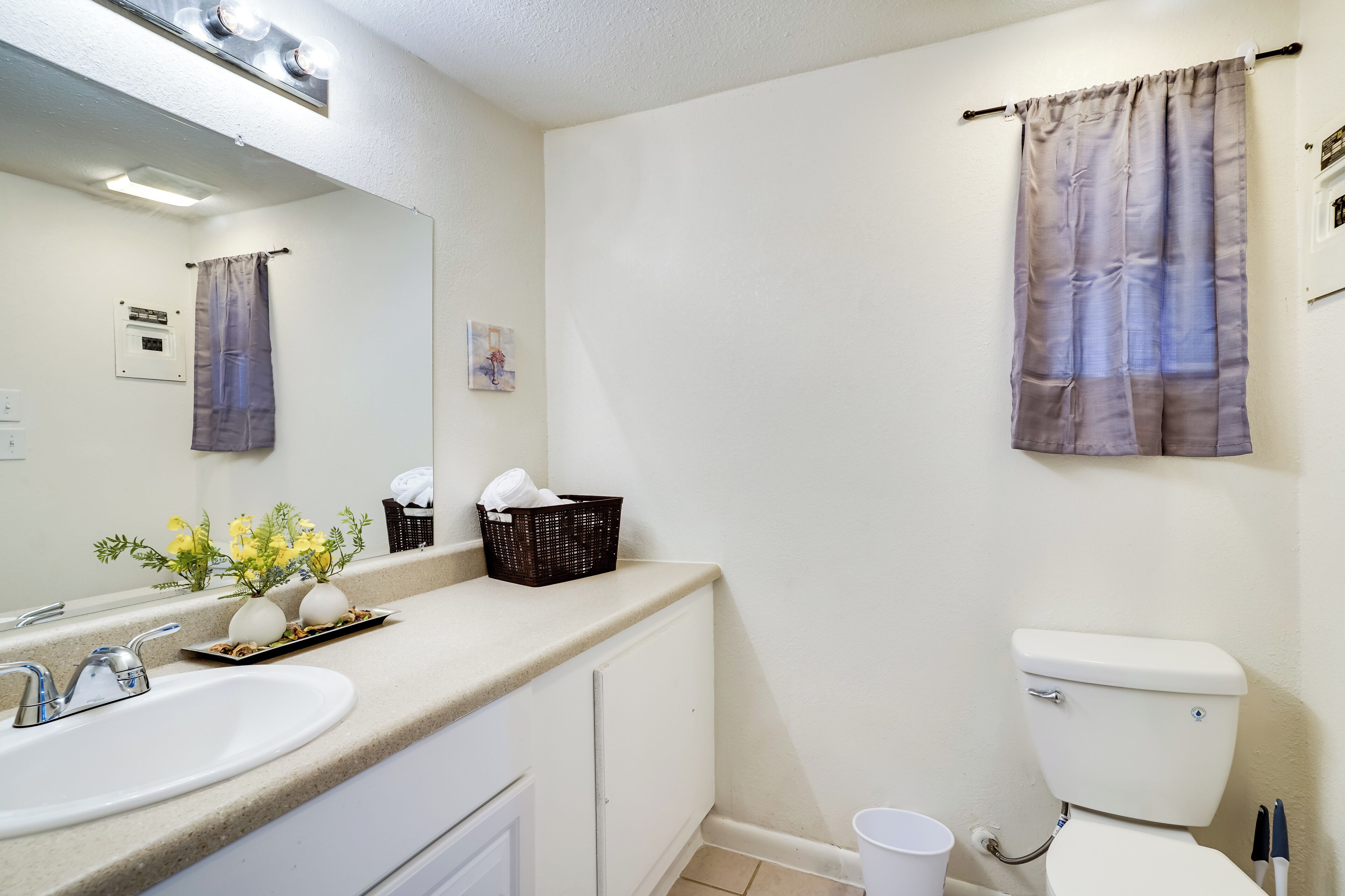 Ein Badezimmer mit Waschbecken, Spiegel, Toilette und Handtuchhalter.
