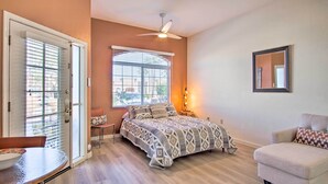 A bedroom with a bed, a chair, a table, and a ceiling fan. - Green Valley Studio in 55+ Community! (Green Valley)