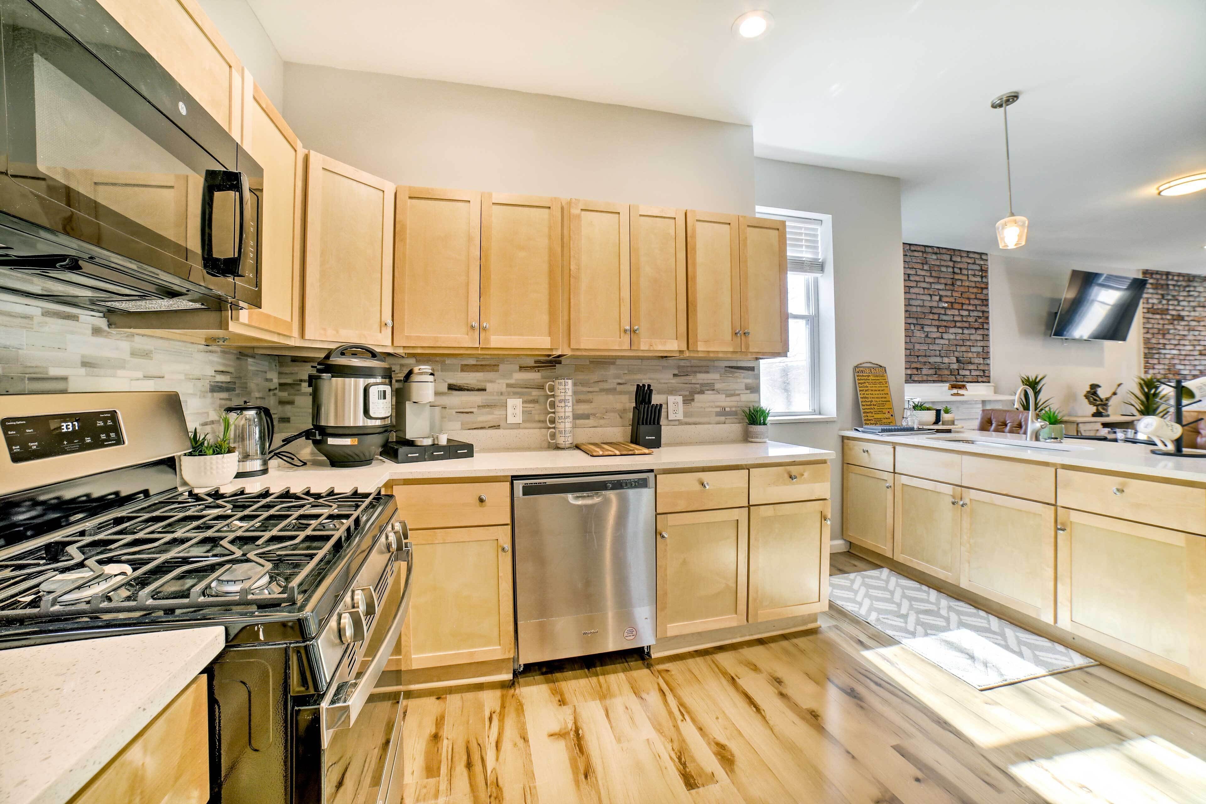 A modern kitchen with wooden cabinets, a stainless steel dishwasher, and a gas stove.