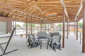 An outdoor wooden deck with seating and a view of a marina. - Gorgeous Granbury Lake House w/ Hot Tub & Dock! (Granbury)