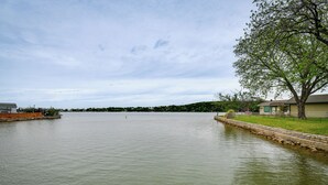 Ein ruhiger See mit einem Steg und einem von Bäumen gesäumten Ufer.