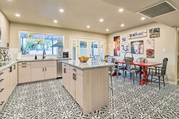 A kitchen with a central island, a dining area with chairs, and artwork on the walls. - Arizona Getaway ~ 3 Mi to Old Town Scottsdale (Scottsdale)