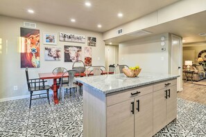 A modern kitchen with a central island, dining area with chairs, and wall art. - Arizona Getaway ~ 3 Mi to Old Town Scottsdale (Scottsdale)