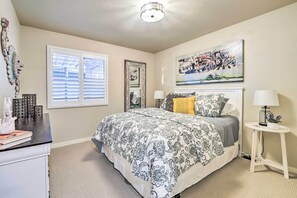 A bedroom with a large bed, a bedside table with a lamp, a window with blinds, a wall-mounted mirror, and a painting. - Arizona Getaway ~ 3 Mi to Old Town Scottsdale (Scottsdale)
