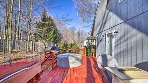 A deck with a hot tub, wooden benches, and a table. - Tobyhanna Home Near Kalahari w/ Lake & Pool Access (Tobyhanna)