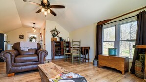 A cozy living room with a leather sofa, wooden coffee table, and a ceiling fan. - Cozy Lewisburg Getaway w/ Deck + Lake Access! (Lewisburg)