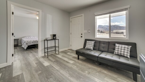 A modern living room with a sofa, a bed, and a dining area.