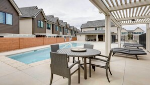 A residential area with a swimming pool, outdoor seating, and modern houses. - Modern Santa Clara Vacation Rental w/ Patio (Santa Clara)