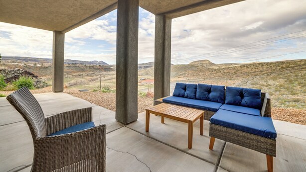 A covered outdoor seating area with a sofa and chairs, overlooking a mountainous landscape. - Toquerville Vacation Rental, Near State Parks! (Toquerville)