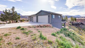 A modern house with a garage, surrounded by a rocky landscape and a clear sky. - Toquerville Vacation Rental, Near State Parks! (Toquerville)