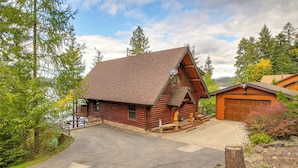 A log cabin with a sloped roof, a front porch, and a garage. - Rustic Gotham Bay Cabin on Lake Coeur D'alene (Harrison)