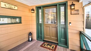 A cabin entrance with a green door, a welcome sign, and two lanterns. - Pet-friendly Cabin in Pinetop-lakeside! (Pinetop)